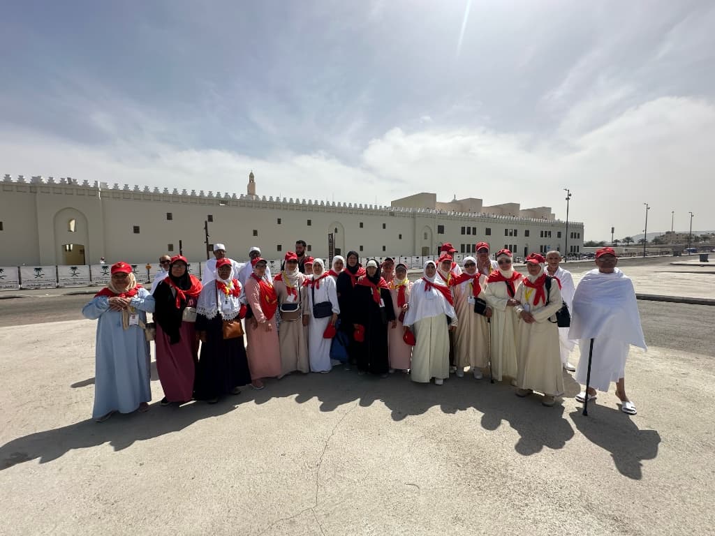 مجموعة المعتمرين بملابس الإحرام والوشاح الأحمر